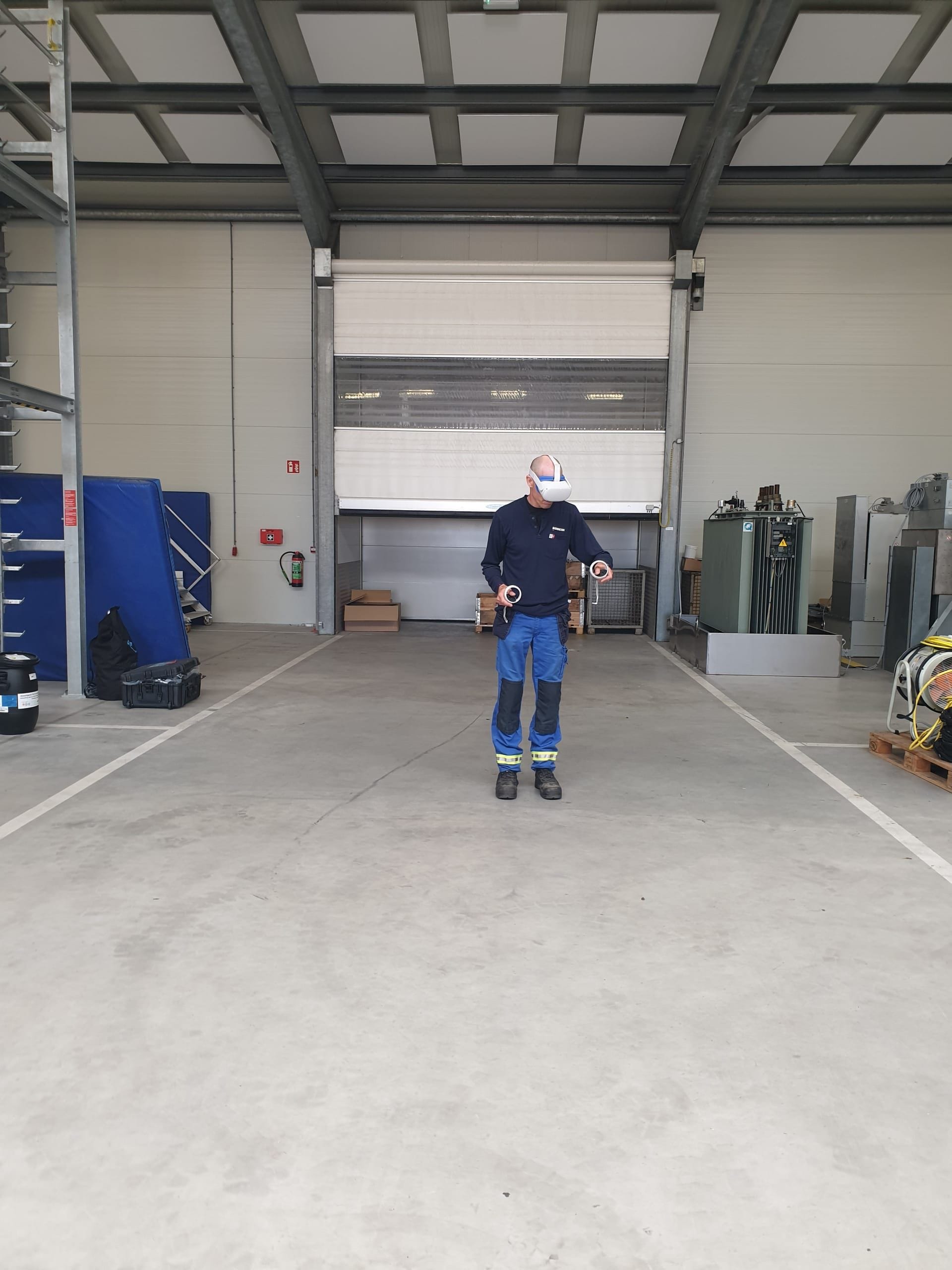 Monteur oefent met een VR-bril en controllers in een werkhal